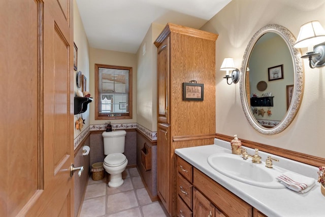 N8891 Gladstone Beach Rd, Fond Du Lac, WI 54937 - bathroom with vanity, tile patterned floors, toilet, and a wainscoted wall