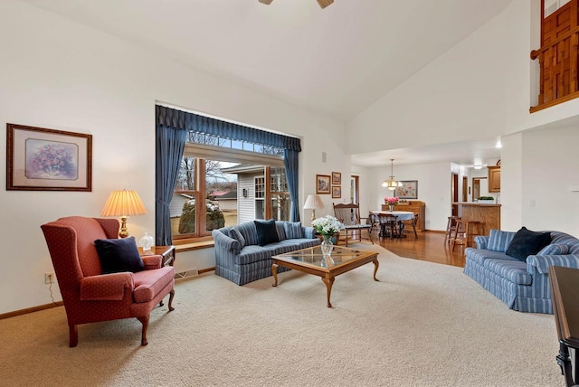 N8891 Gladstone Beach Rd, Fond Du Lac, WI 54937 - carpeted living room featuring high vaulted ceiling, visible vents, baseboards, and ceiling fan with notable chandelier
