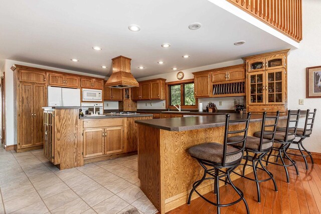 957 Whispering Ln, Hazel Green, WI 53811 - kitchen featuring a sink, a kitchen breakfast bar, dark countertops, island range hood, and white microwave