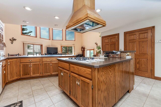957 Whispering Ln, Hazel Green, WI 53811 - kitchen with premium range hood, a center island, brown cabinetry, white gas cooktop, and dark countertops