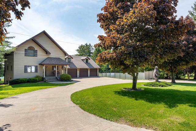 957 Whispering Ln, Hazel Green, WI 53811 - view of front facade featuring an attached garage, fence, curved driveway, and a front yard