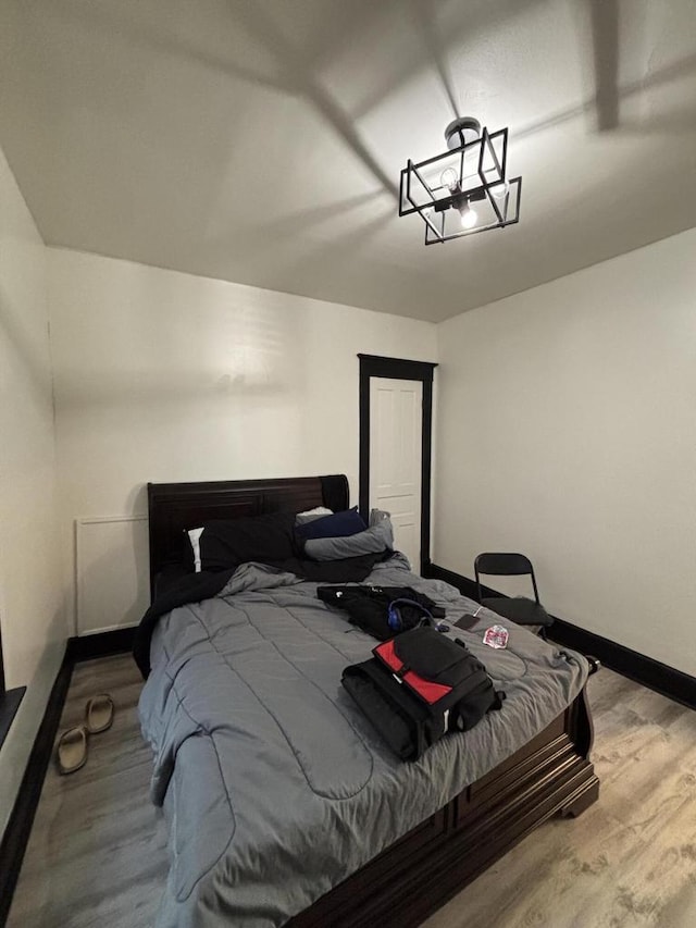 bedroom featuring baseboards and wood finished floors