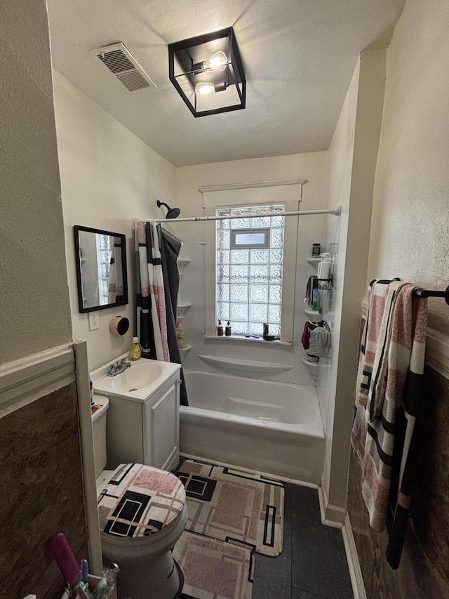 full bath with visible vents, toilet, vanity, and shower / bath combination