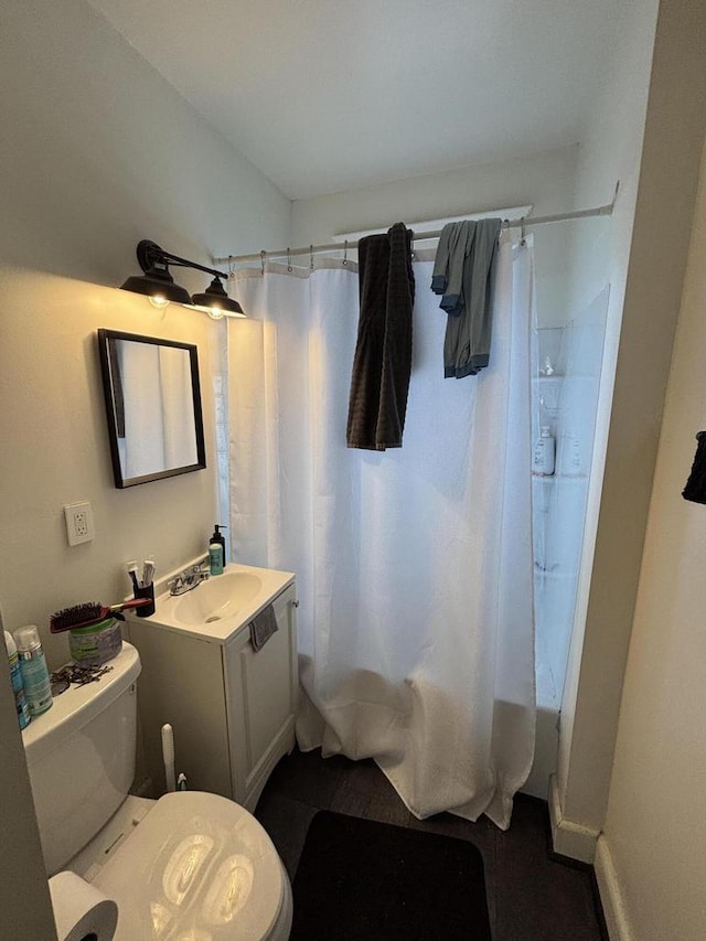 bathroom featuring toilet, shower / bathtub combination with curtain, and vanity