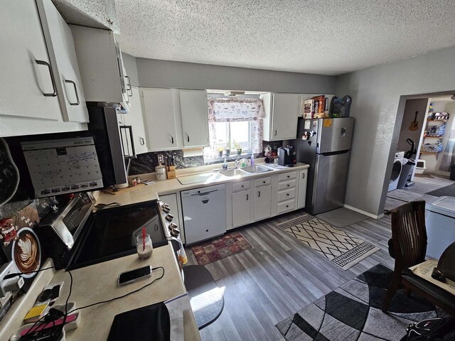 233 Highland St, Belmont, WI 53510 - kitchen featuring light countertops, dark wood-style flooring, a sink, freestanding refrigerator, and white dishwasher