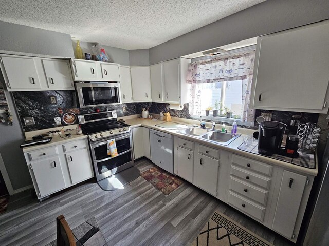 233 Highland St, Belmont, WI 53510 - kitchen with white cabinetry, light countertops, dark wood-type flooring, a sink, and appliances with stainless steel finishes