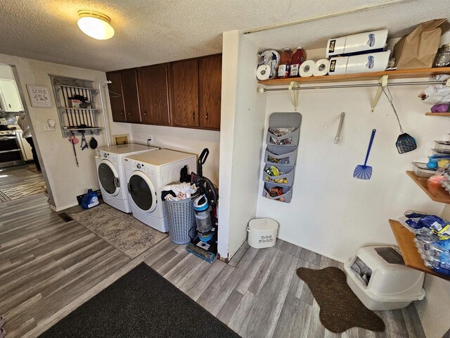 233 Highland St, Belmont, WI 53510 - washroom with washer and clothes dryer, cabinet space, a textured ceiling, and wood finished floors