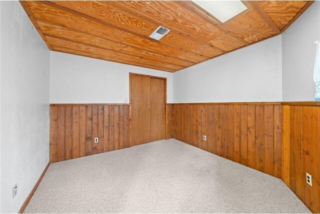 8375 N Bass Lake Rd, Danbury, WI 54830 - unfurnished room featuring wainscoting, wood walls, carpet, and wood ceiling