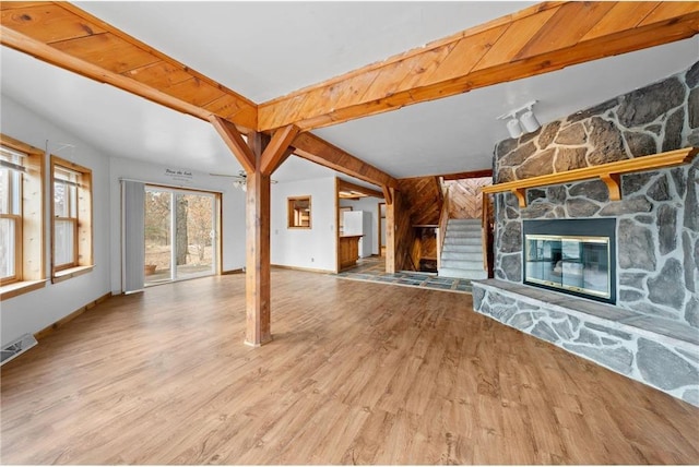 8375 N Bass Lake Rd, Danbury, WI 54830 - unfurnished living room featuring baseboards, beamed ceiling, visible vents, a fireplace, and wood finished floors