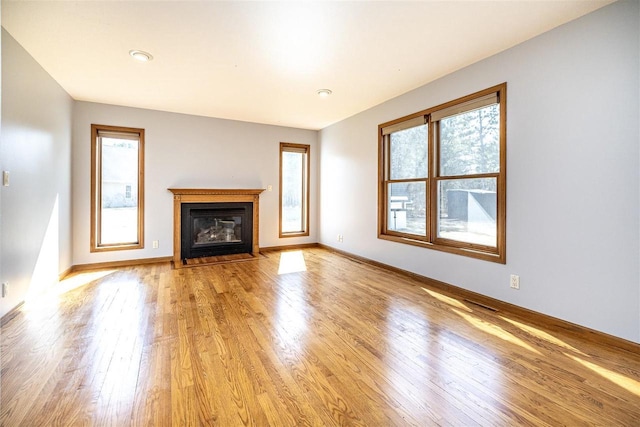 836 Westwind Dr, Black River Falls, WI 54615 - unfurnished living room with a fireplace with flush hearth, baseboards, and light wood-style floors