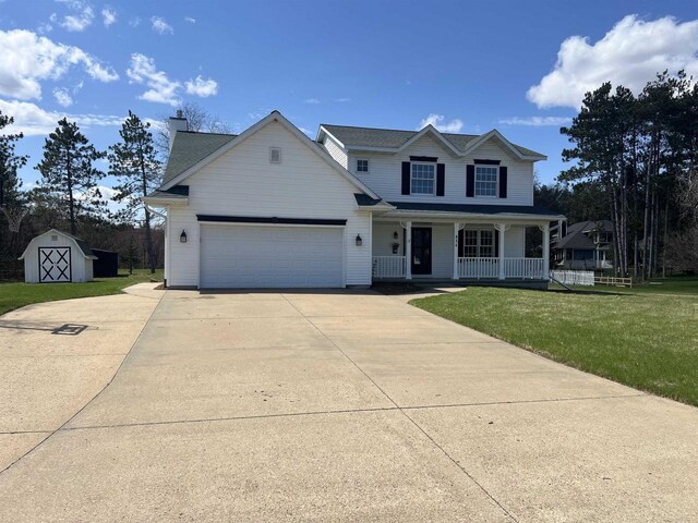 836 Westwind Dr, Black River Falls, WI 54615 - traditional-style home featuring a storage shed, concrete driveway, covered porch, a garage, and a front yard