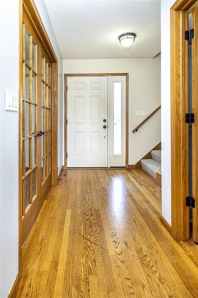836 Westwind Dr, Black River Falls, WI 54615 - foyer entrance with stairway, baseboards, wood finished floors, and french doors