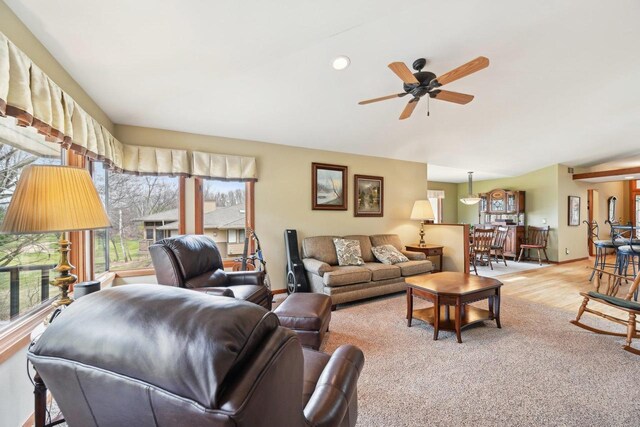living room featuring baseboards, ceiling fan, wood finished floors, and vaulted ceiling
