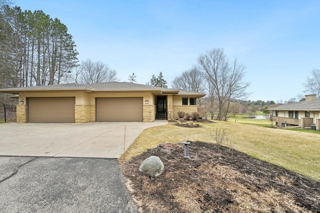 prairie-style house with concrete driveway, stucco siding, an attached garage, stone siding, and a front yard