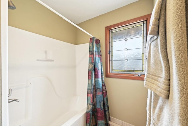 bathroom with shower / bath combo with shower curtain and baseboards