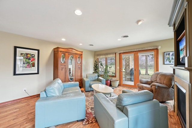 living area featuring recessed lighting, french doors, light wood finished floors, visible vents, and a fireplace