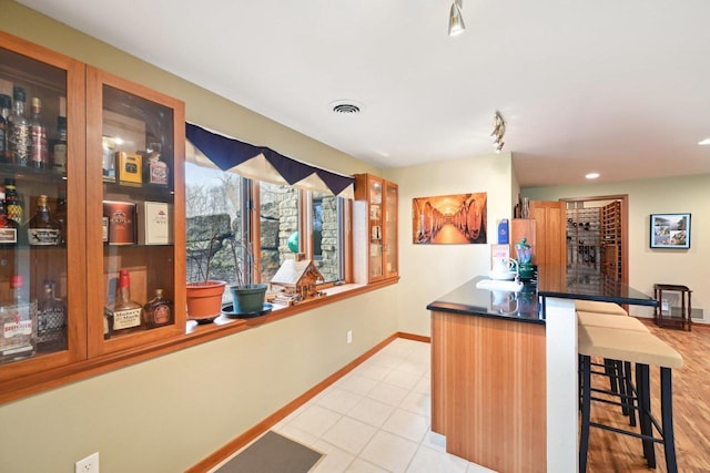 bar featuring light tile patterned flooring, wet bar, baseboards, visible vents, and recessed lighting