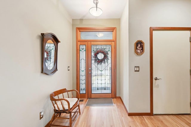 foyer with light wood finished floors and baseboards