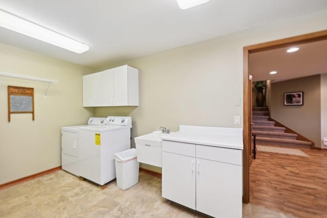 washroom with a sink, separate washer and dryer, baseboards, cabinet space, and recessed lighting