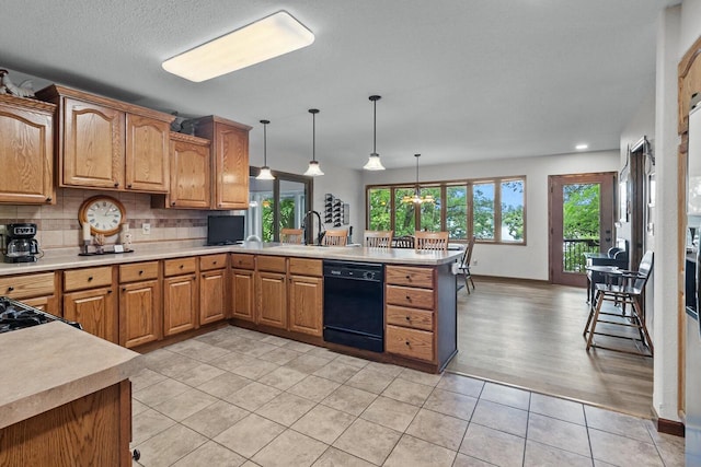 W1260 S Shore Dr, Palmyra, WI 53156 - kitchen featuring light countertops, a sink, backsplash, dishwasher, and a peninsula