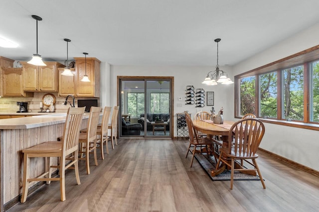 W1260 S Shore Dr, Palmyra, WI 53156 - dining area with baseboards, light wood-style floors, and a chandelier