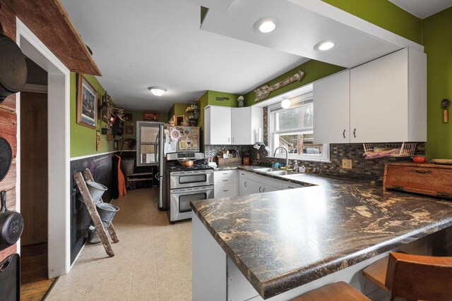 505 S Main St, Edgerton, WI 53534 - kitchen with a peninsula, dark countertops, white cabinetry, a sink, and double oven range