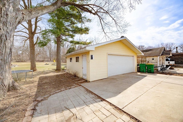 505 S Main St, Edgerton, WI 53534 - view of property exterior with a detached garage, an outdoor structure, and a trampoline