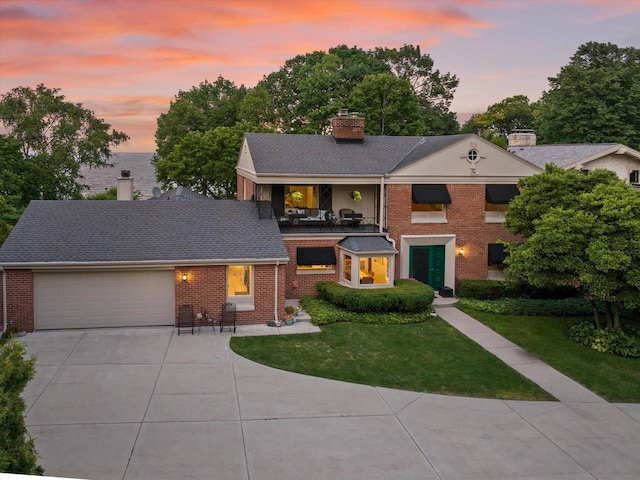 4696 N Lake Dr, Whitefish Bay, WI 53211 - view of front of house with brick siding, a yard, and driveway