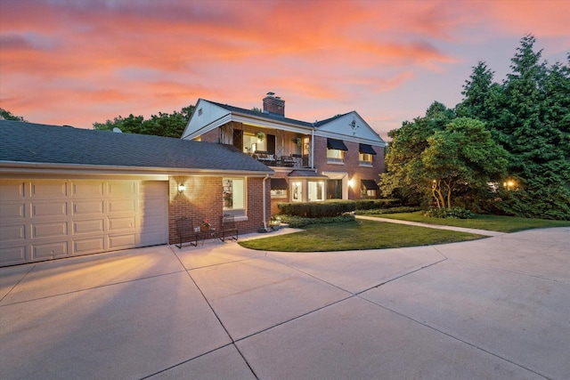4696 N Lake Dr, Whitefish Bay, WI 53211 - traditional-style house featuring a yard, an attached garage, a balcony, brick siding, and driveway