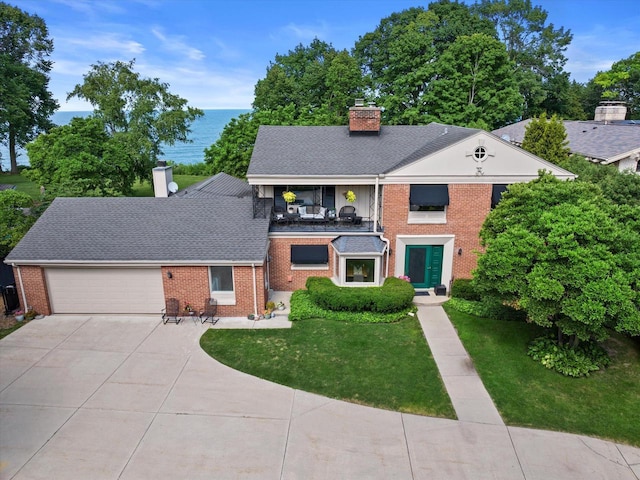 4696 N Lake Dr, Whitefish Bay, WI 53211 - view of front of property featuring an attached garage, a chimney, concrete driveway, brick siding, and a balcony
