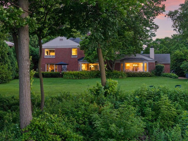 4696 N Lake Dr, Whitefish Bay, WI 53211 - view of front of property featuring brick siding, a chimney, and a lawn