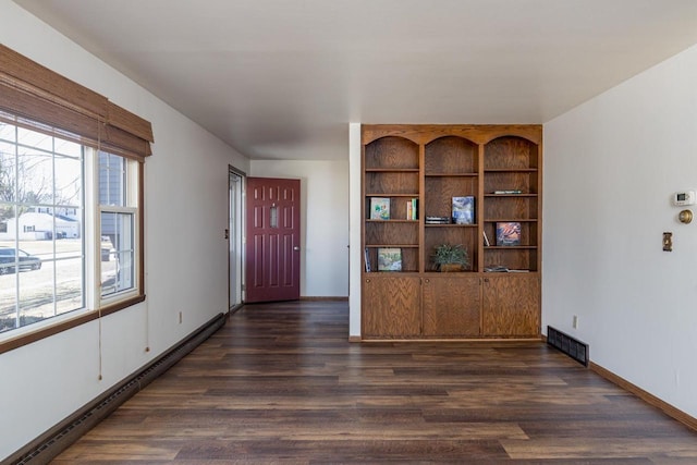 entryway with baseboards, baseboard heating, visible vents, and dark wood-type flooring