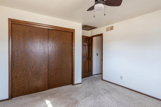 unfurnished bedroom with light carpet, baseboards, a closet, and visible vents