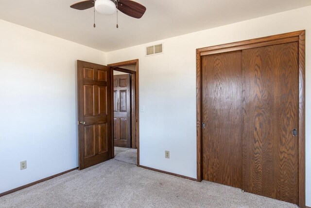 unfurnished bedroom with a closet, baseboards, visible vents, and light colored carpet