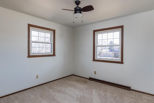 carpeted empty room featuring baseboards, ceiling fan, and baseboard heating