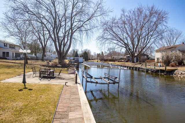 view of dock featuring a lawn and a water view