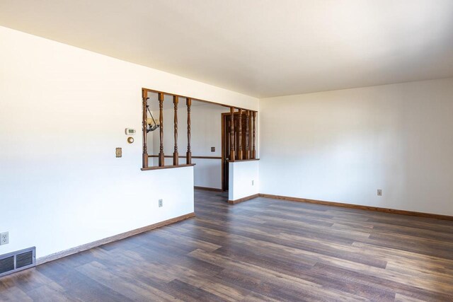 unfurnished room with dark wood finished floors, baseboards, and visible vents