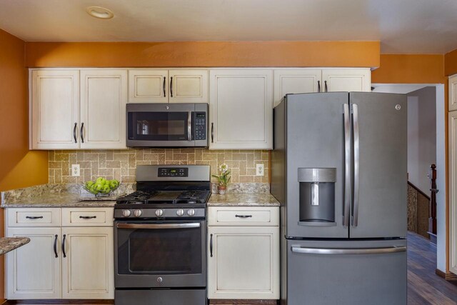 kitchen featuring white cabinetry, tasteful backsplash, appliances with stainless steel finishes, and light stone counters