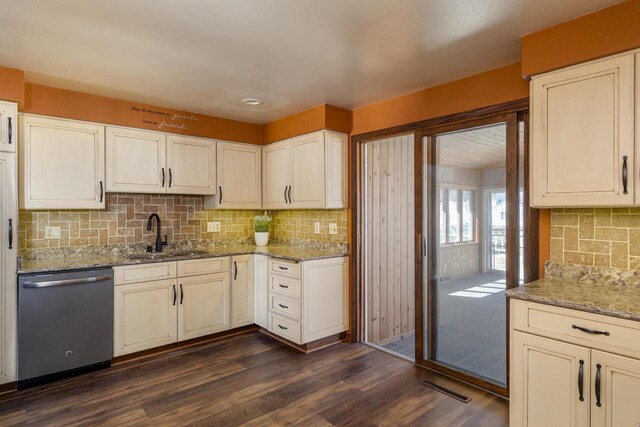 kitchen with a sink, light stone countertops, dishwasher, visible vents, and dark wood-type flooring