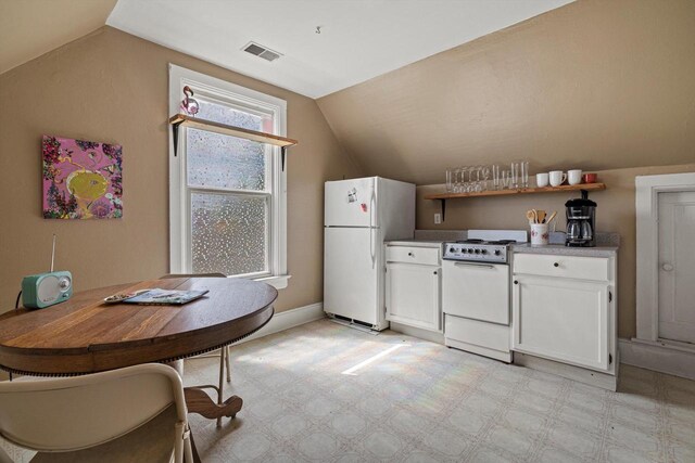 721 N St, Lake Geneva, WI 53147 - kitchen featuring white cabinetry, visible vents, lofted ceiling, and white appliances