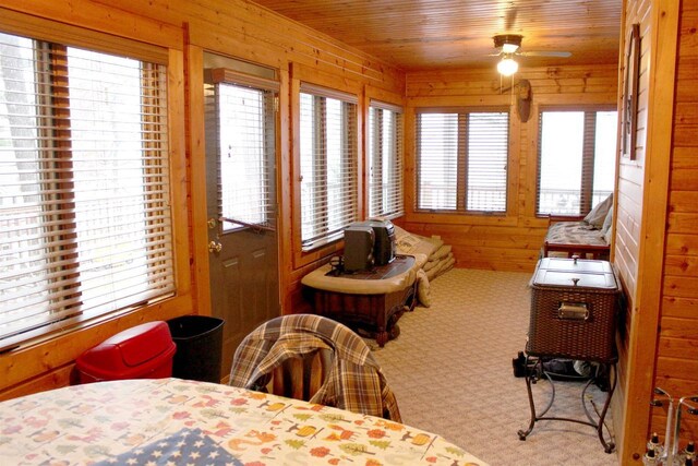1885 20th Ave, Arkdale, WI 54613 - carpeted dining space featuring a ceiling fan, wood walls, and wood ceiling