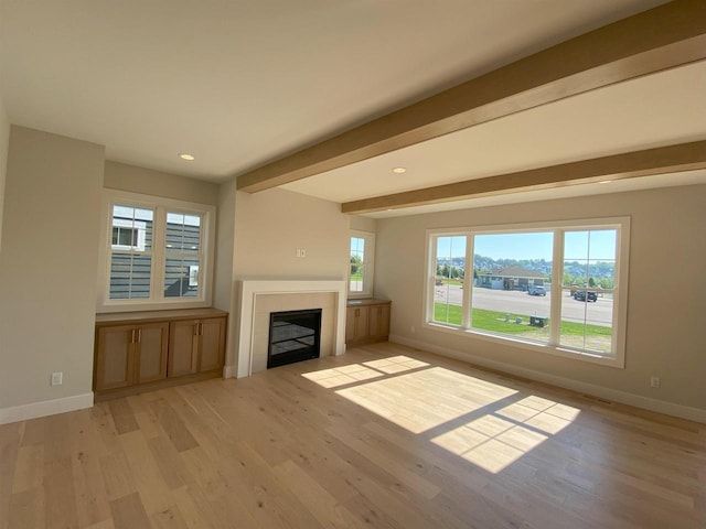 901 Westbridge Ct, Waunakee, WI 53597 - unfurnished living room featuring baseboards, light wood-style floors, a tiled fireplace, recessed lighting, and beam ceiling