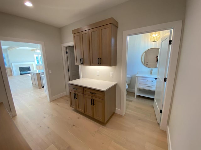901 Westbridge Ct, Waunakee, WI 53597 - kitchen with a sink, light wood finished floors, light countertops, baseboards, and recessed lighting