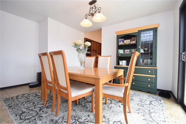 8160 Waldora Rd, Siren, WI 54872 - dining space featuring light tile patterned floors, a notable chandelier, and baseboards