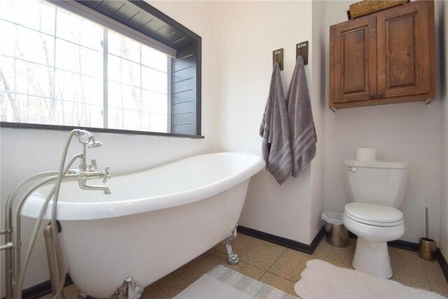 8160 Waldora Rd, Siren, WI 54872 - bathroom featuring a soaking tub, baseboards, and toilet