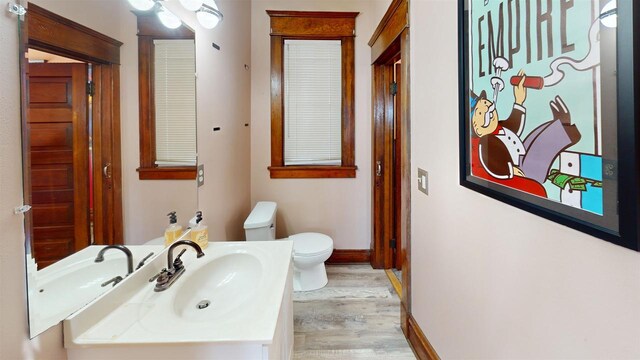 813 Main St, Black River Falls, WI 54615 - bathroom with baseboards, toilet, vanity, and wood finished floors