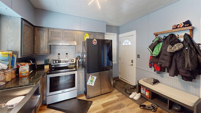 813 Main St, Black River Falls, WI 54615 - kitchen with stainless steel appliances, dark brown cabinetry, under cabinet range hood, light wood-style floors, and wainscoting