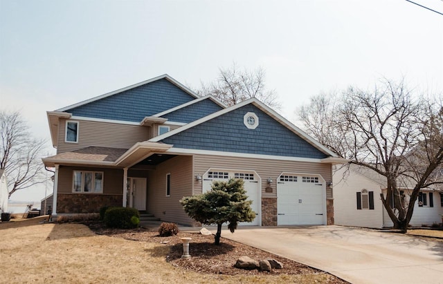 craftsman-style home with stone siding, an attached garage, and driveway