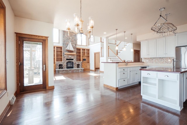 kitchen featuring freestanding refrigerator, white cabinetry, built in features, and dark wood-style floors