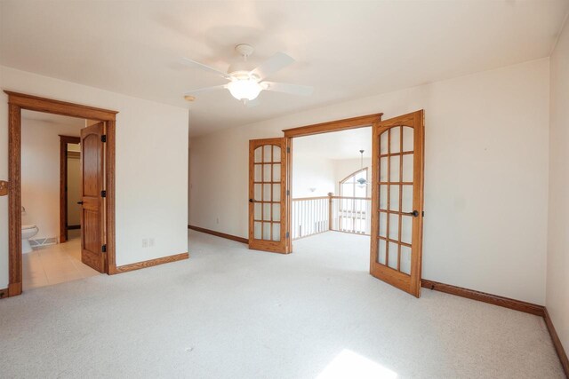 spare room with light carpet, baseboards, and ceiling fan
